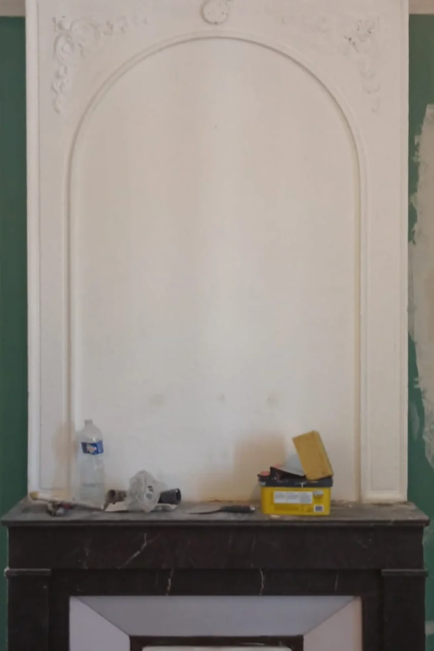 Cheminée en marbre et trumeau en arche d'une chambre avant travaux de rénovation, appartement haussmannien à Montpellier