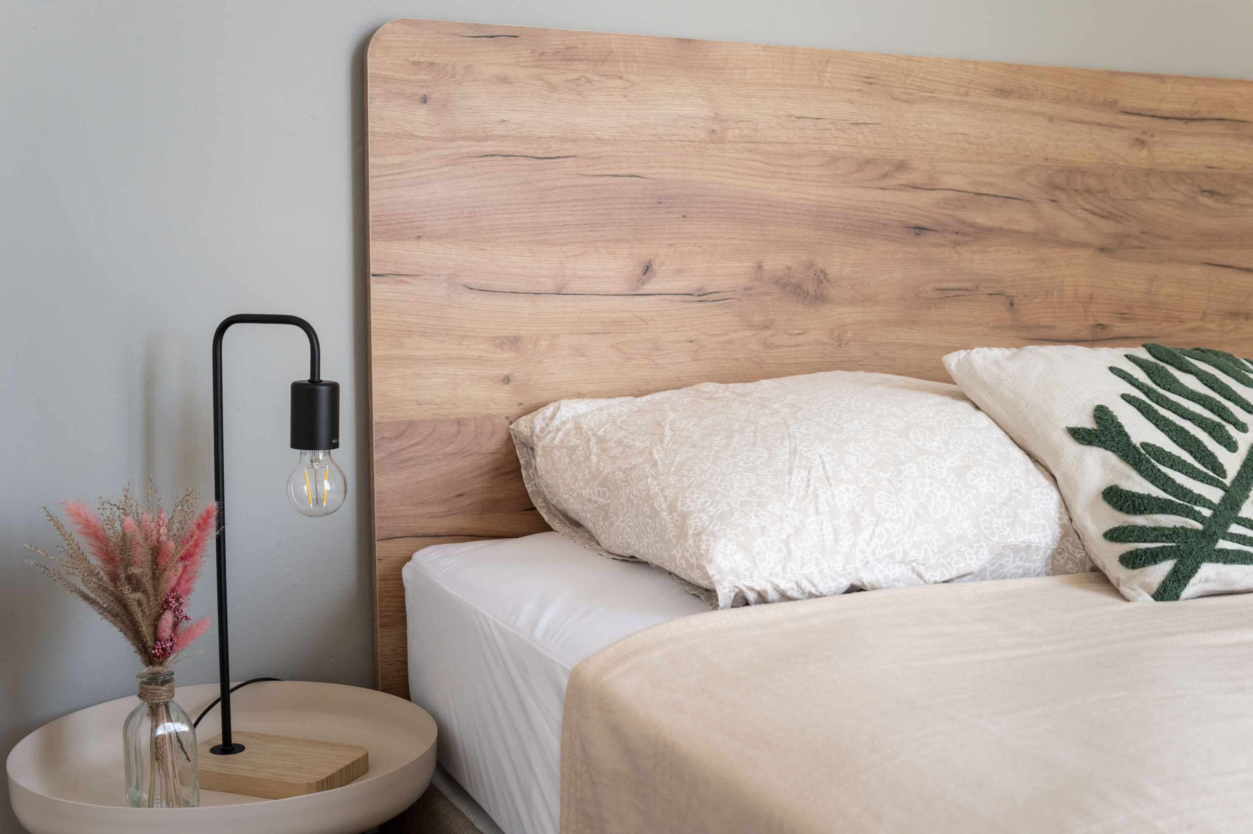 Tête de lit en bois et chevet dans une chambre de colocation rénovée, Montpellier